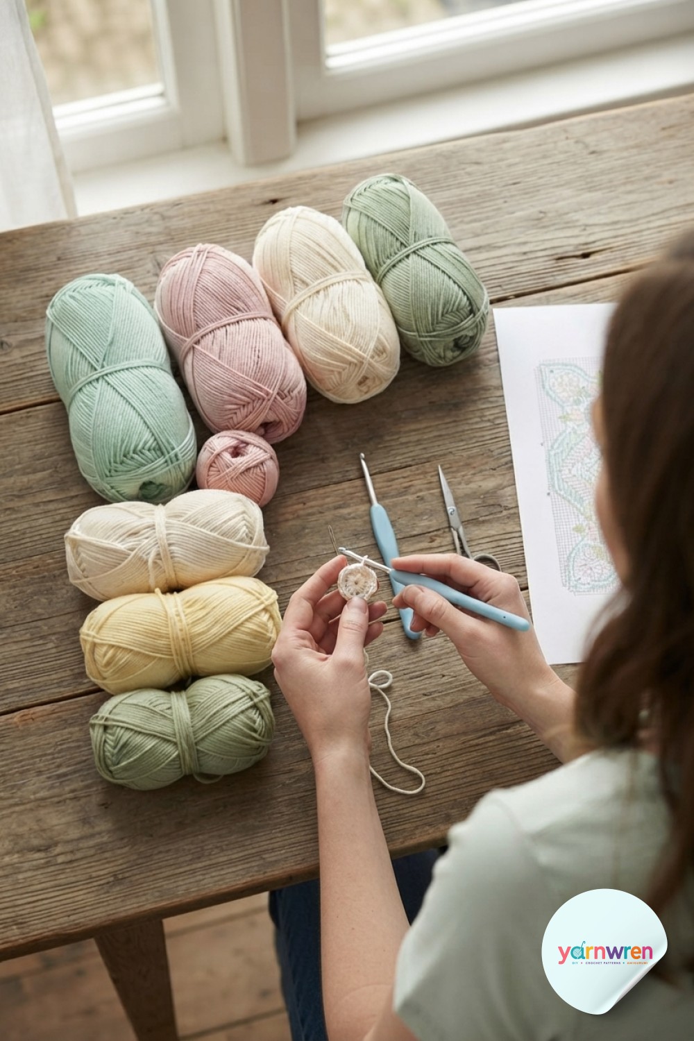 Hands begin the first magic ring of the crochet flower blanket pattern, forming the tiny cream center round.