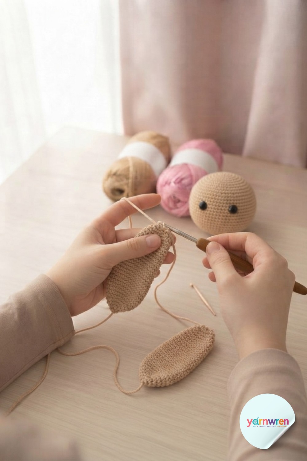 Two flat floppy ear pieces crocheted for the crochet puppy amigurumi resting beside the finished head